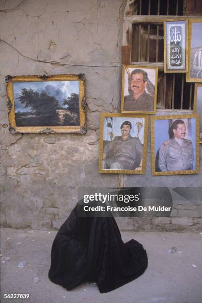 Beggar under Saddam Husayn's portraits. Bassora , in May, 1991. FDM-907-12.