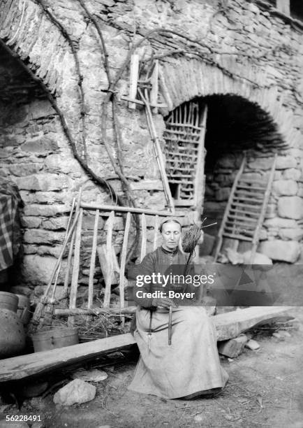 Farmer spinning the wool on her distaff. France, around 1913.