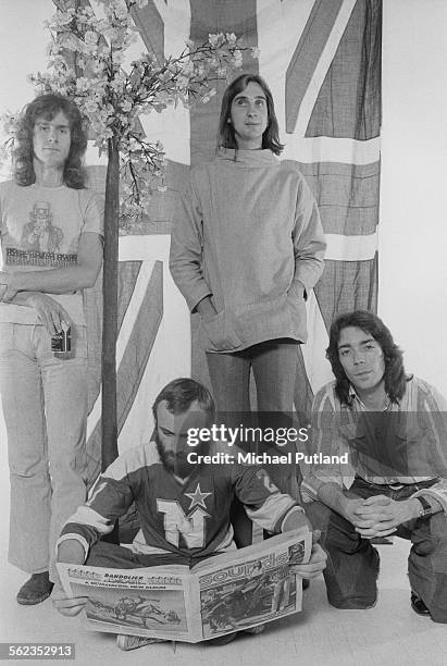 British progressive rock group Genesis posing in front of a union jack flag, 4th September 1975. Left to right: keyboard player Tony Banks,...