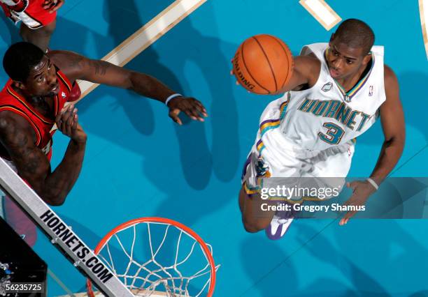 Chris Paul of the New Orleans/Oklahoma City Hornets gets in for a layup past Marvin Williams of the Atlanta Hawks during a NBA game on November 18,...