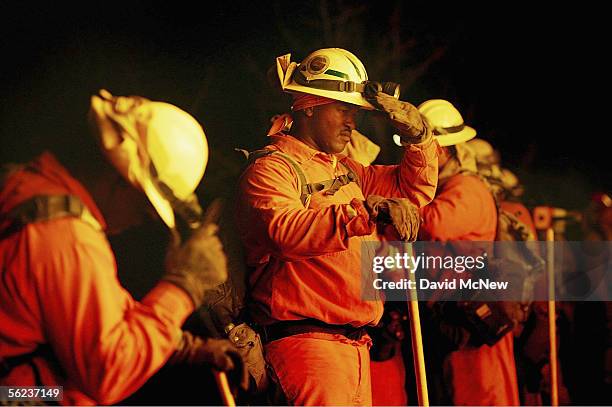 Inmate hand crew memebrs shield their faces from high temperatures as flames grow in their backfire at the School Canyon Fire on November 18, 2005 in...