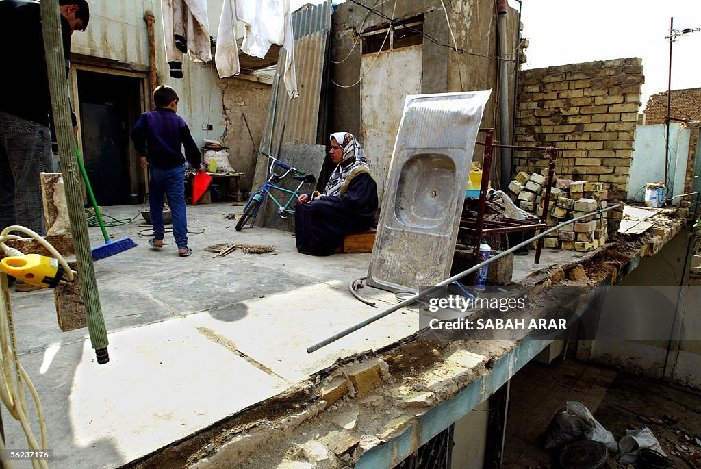 An Iraqi woman sits in her destroyed kit