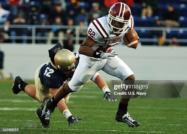 In this handout from the U.S. Navy, U.S. Naval Academy linebacker Jake Biles falls short of tackling Temple Owls wide receiver Bruce Francis of the...