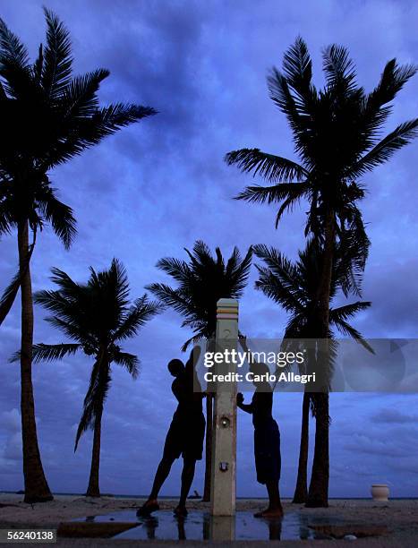 Two boys wash off in the twilight after a day at the beach November 19, 2005 in Hollywood, Florida. Tropical Storm Gamma approaches South Florida as...