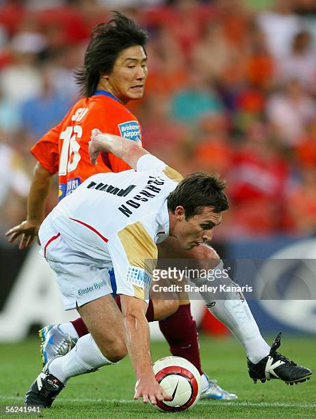 Richard Johnson of the Jets is tackled by Hyuk Su Seo of the Roar during the A-League match between the Queensland Roar and the Newcastle Jets at...