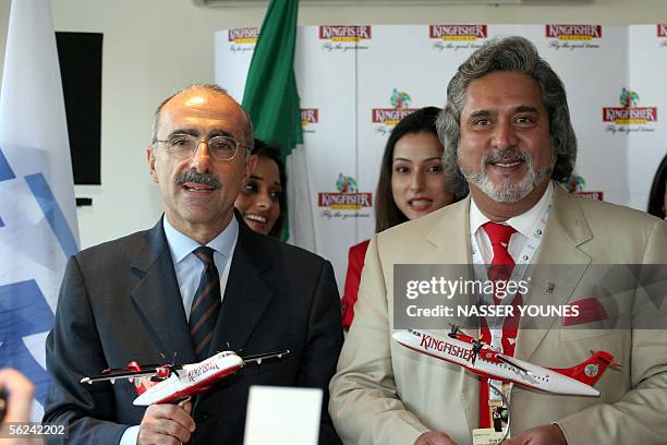 Indian airline Kingfisher owner Vijya Mallya holds an aircraft model with ATR CEO Filippo Bagnato during a press conference to announce a 350 million...