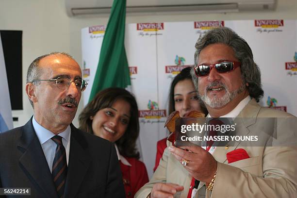 Indian airline Kingfisher owner Vijya Mallya holds a crystal gift from ATR CEO Filippo Bagnato during a press conference to announce a 350 million US...
