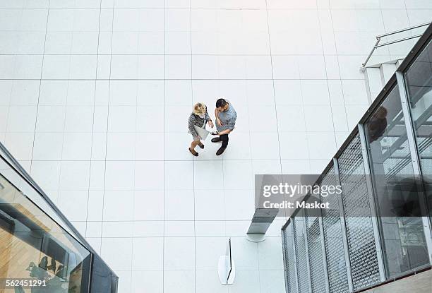 high angle view of business colleagues using digital tablet in modern office - person standing far stockfoto's en -beelden