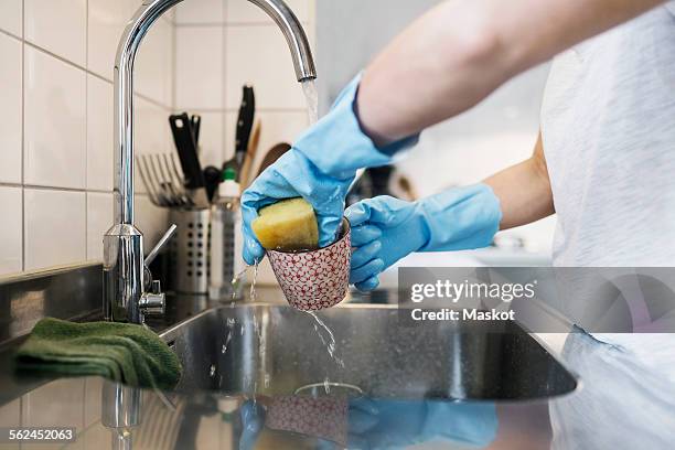 midsection of woman washing glass with scouring pad at sink - white glove cleaning stock pictures, royalty-free photos & images