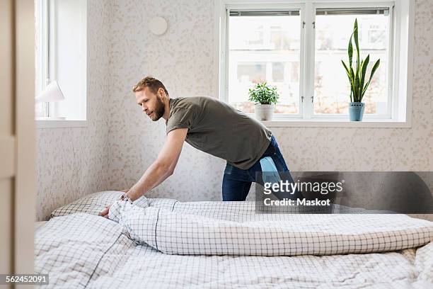 man making bed - make stockfoto's en -beelden