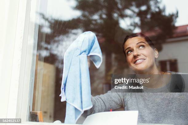 woman cleaning glass of house window - frau putzen stock-fotos und bilder