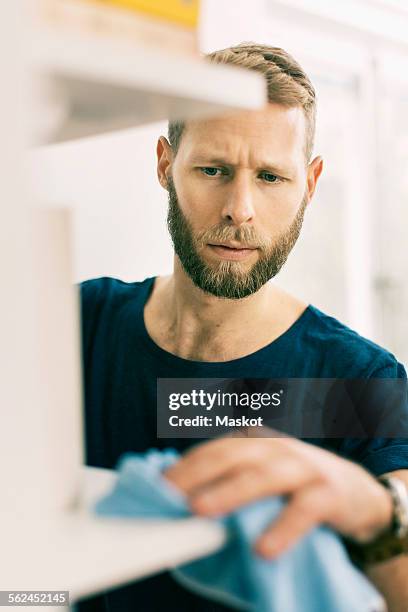man cleaning shelf with rag - man dusting stock pictures, royalty-free photos & images