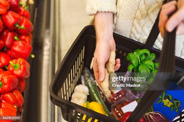 midsection of man buying groceries at supermarket - cesto de compras imagens e fotografias de stock