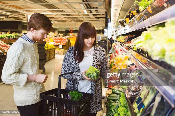 young couple buying vegetables at supermarket - chou romanesco stock pictures, royalty-free photos & images