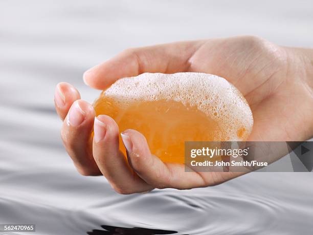 hand holding bar soap - seifenstück stock-fotos und bilder