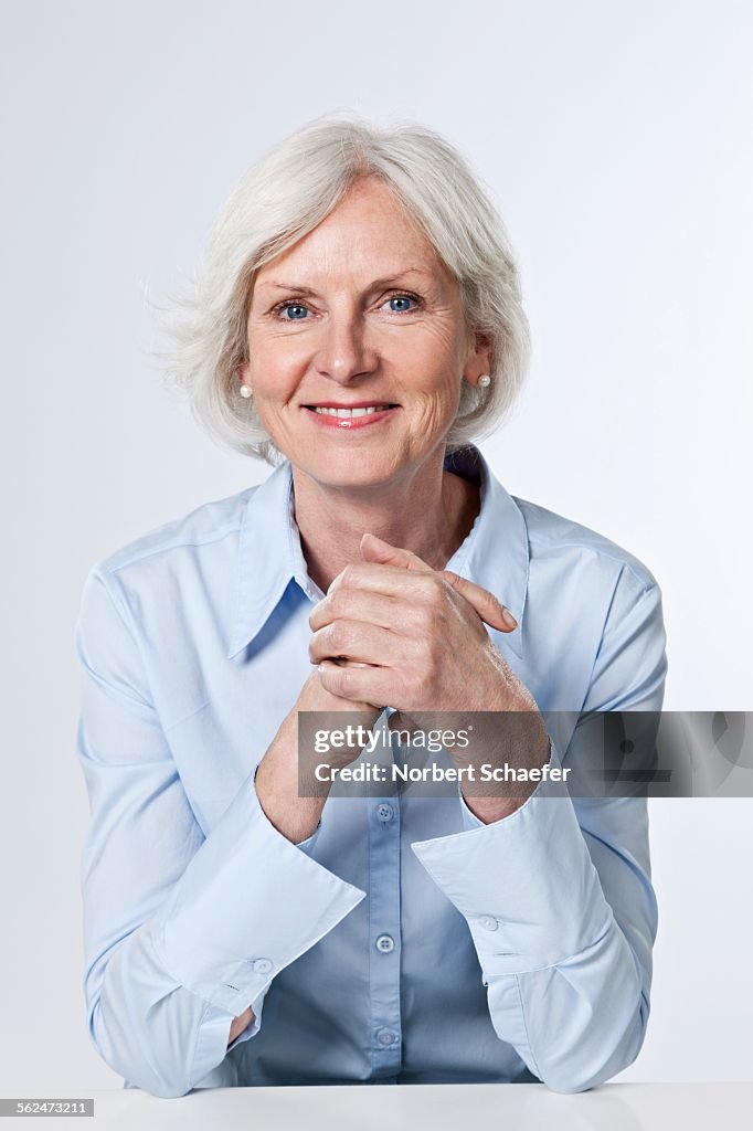 Studio portrait of middle-aged woman smiling