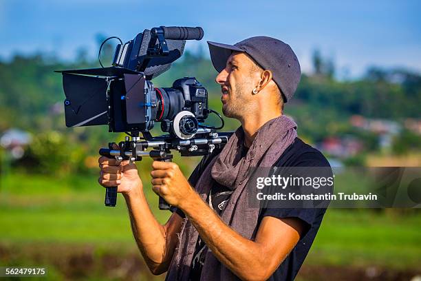 a cameraman holding camera in bali,indonesia. - equipe cinematografica foto e immagini stock