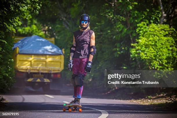 man riding on a longboard skate, bali, indonesia. - kneepad stock pictures, royalty-free photos & images