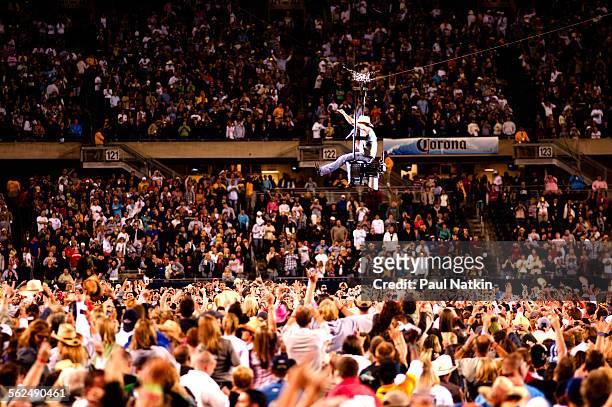 Perched on a swing, American country musician Kenny Chesney performs above the audience at Soldier Field, Chicago, Illinois, June 13, 2009.