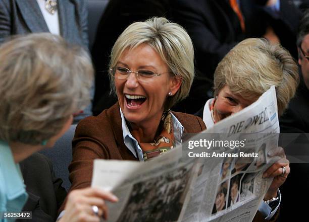 Sabine Christiansen, television presenter, holds a newspaper while she laughs during the announcement of the chancellorship voting at the lower house...