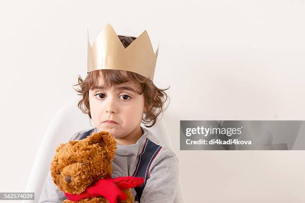 sad boy wearing paper crown - paper crown stock pictures, royalty-free photos & images