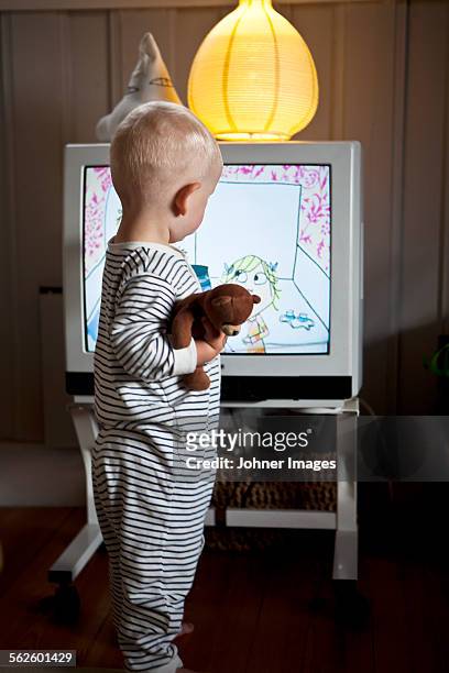 baby boy standing in front of tv - cartoon tv stock pictures, royalty-free photos & images