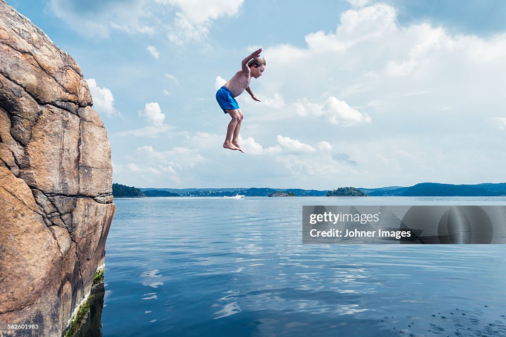 Boy jumping into sea