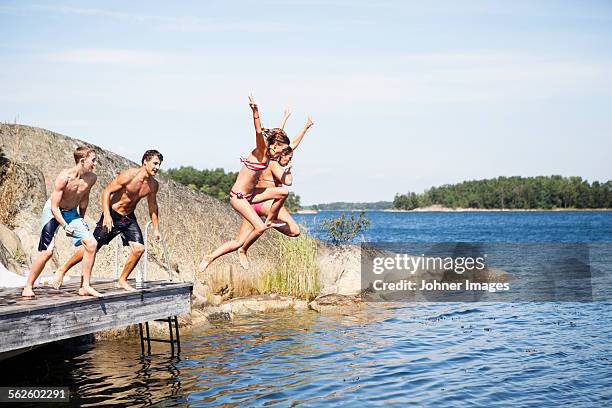 teenagers jumping into water - sweden archipelago stock pictures, royalty-free photos & images