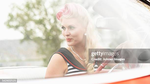 woman wearing retro clothes sitting in vintage car - rockabilly stock pictures, royalty-free photos & images