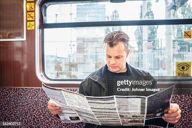 man reading map in train - berlin map stock pictures, royalty-free photos & images