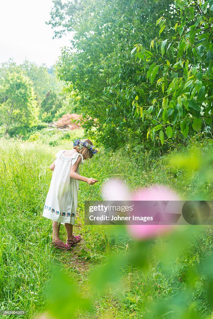 Girl wearing flower wreath on meadow