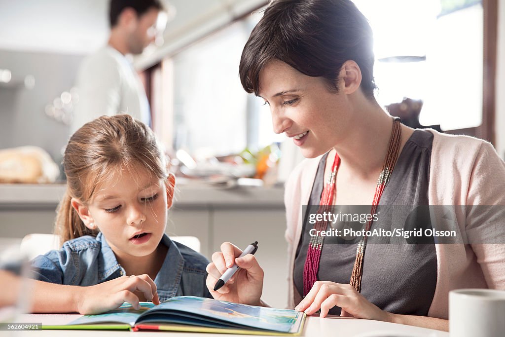 Mother and young daughter reading together