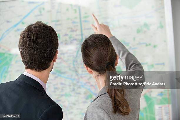 man and woman looking at paris metro map together - looking at subway map stock pictures, royalty-free photos & images