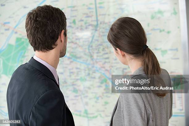 man and woman looking at paris metro map together - looking at subway map stock pictures, royalty-free photos & images