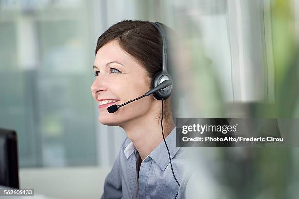 receptionist wearing headset, smiling cheerfully - telephone worker stock pictures, royalty-free photos & images