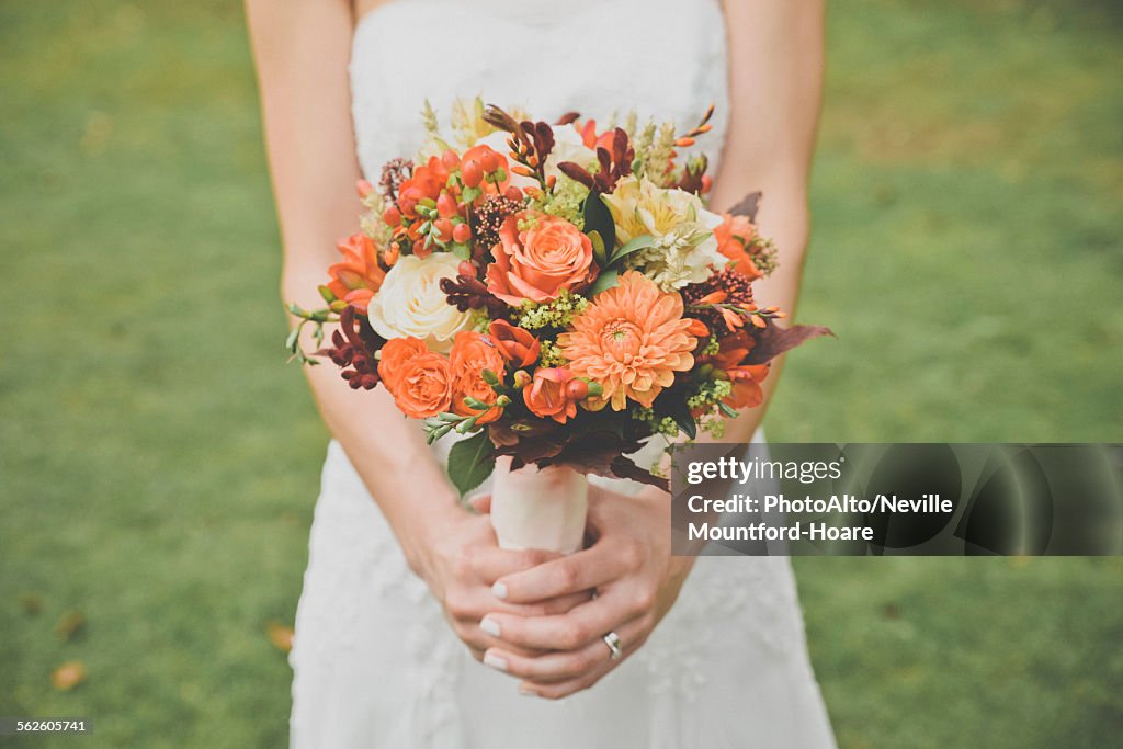 Bride holding bouquet, cropped