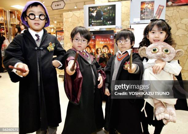 Harry Potter fans dressed as Harry Potter and Hermione Granger pose with magic wands during a Harry Potter exhibition which displays stage garments...
