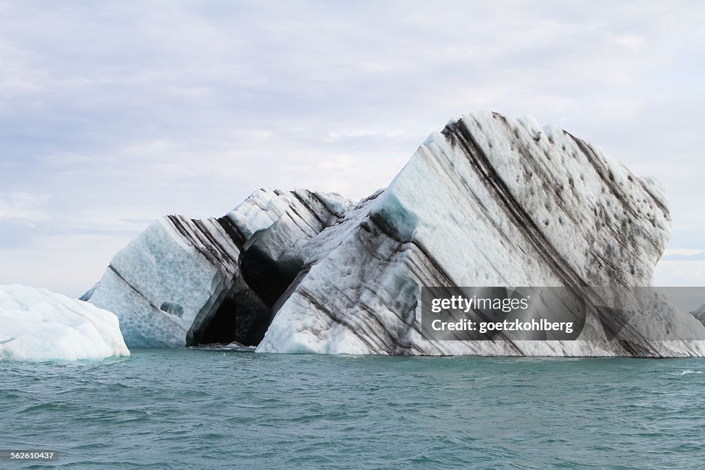 Black striped icebergs floating in Joekulsarlon lagoon, Iceland