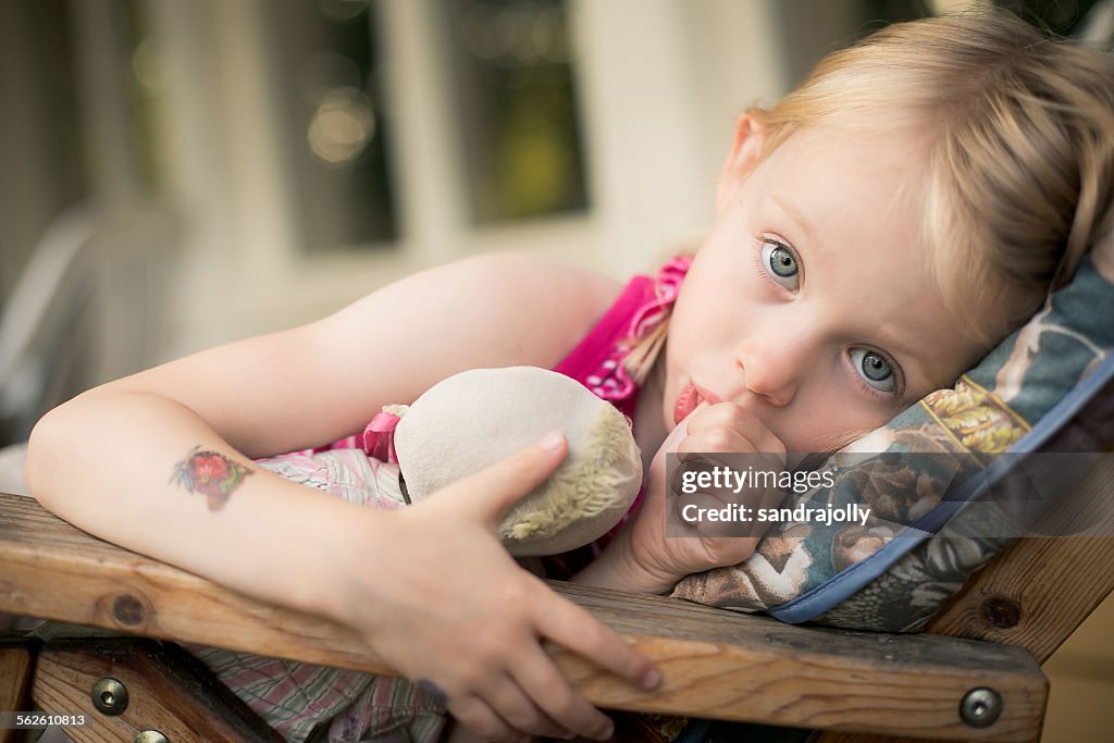 Girl lying in a chair sucking her thumb