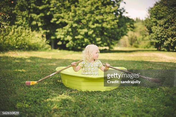 Girl sitting in a rowing boat in the garden
