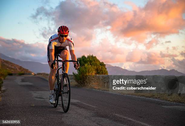 man cycling at sunset, corsica, france - corsica france stock pictures, royalty-free photos & images