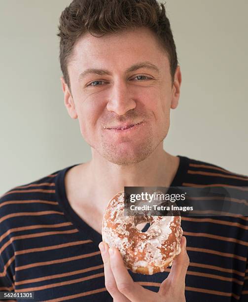 portrait of man eating donut - donut man stock pictures, royalty-free photos & images