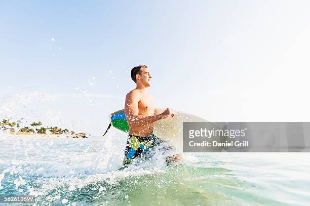 usa, florida, west palm beach, young surfer running - west palm beach foto e immagini stock