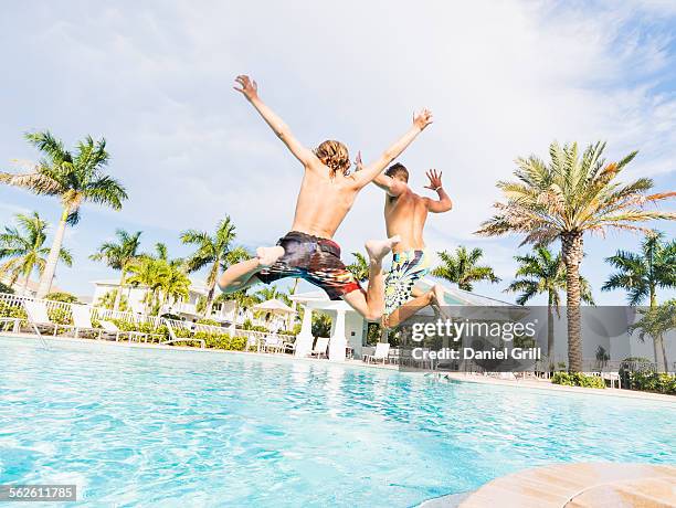 usa, florida, jupiter, boy (8-9) diving into swimming pool with his brother - freibad stock-fotos und bilder