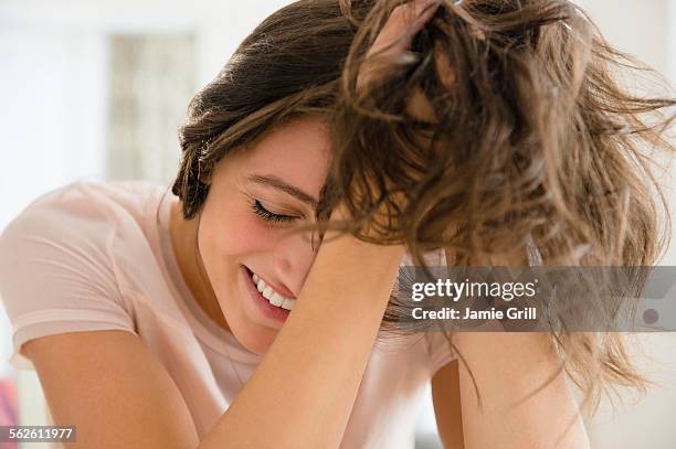 woman with hands in hair smiling - hand in hair stock pictures, royalty-free photos & images
