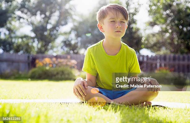 usa, colorado, boy (6-7) sitting in grass - pernas cruzadas imagens e fotografias de stock