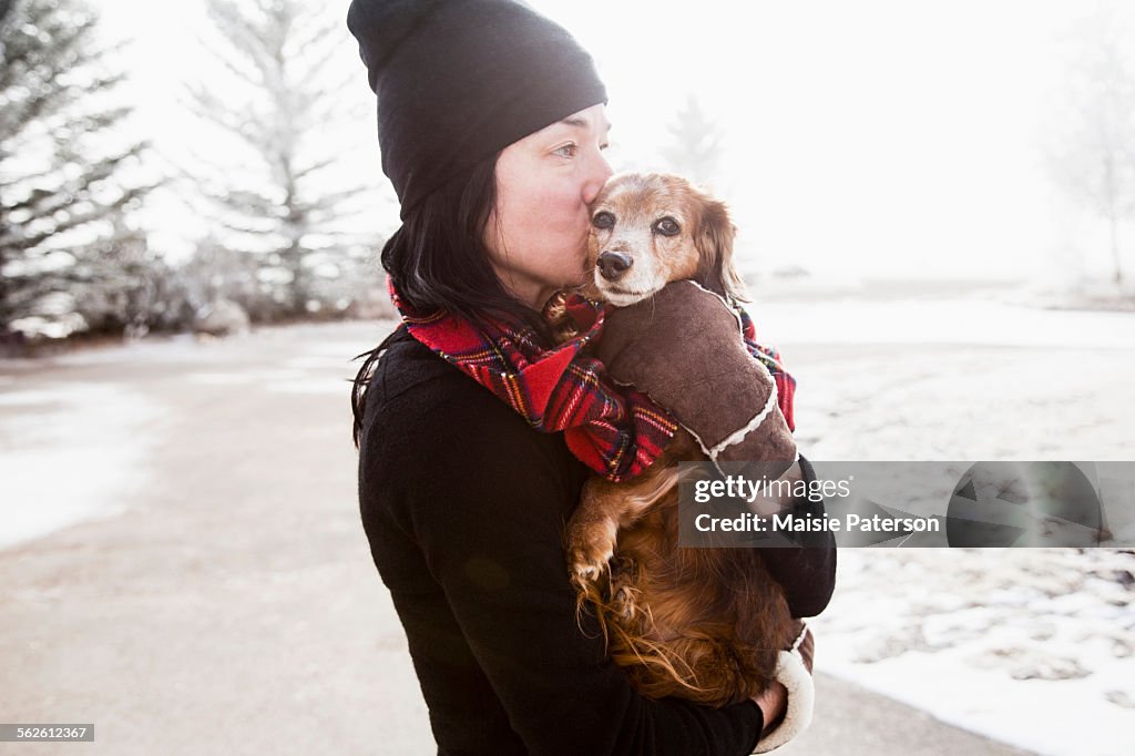 USA, Colorado, Woman holding and kissing dog