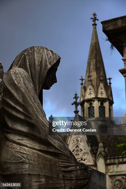 argentina, buenos aires, close up of sculpture and church tower in recoleta cemetery - la recoleta cemetery stock pictures, royalty-free photos & images