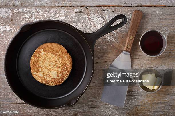 directly above view of kitchen utensils and pancake on rustic wooden table - küchenspatel stock-fotos und bilder