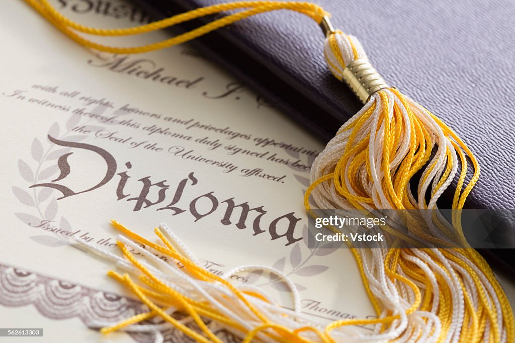 Close-up view of graduation tassel and diploma